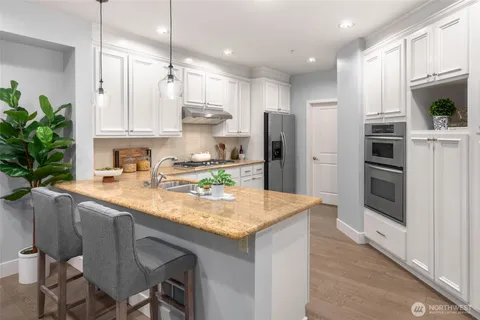 a kitchen with granite countertop a sink and stainless steel appliances