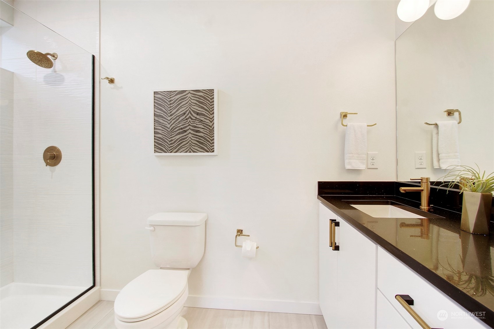 1213 East Mercer Street Seattle, WA 98102 - Photo 18 of 29 a bathroom with a granite countertop sink a toilet and a shower