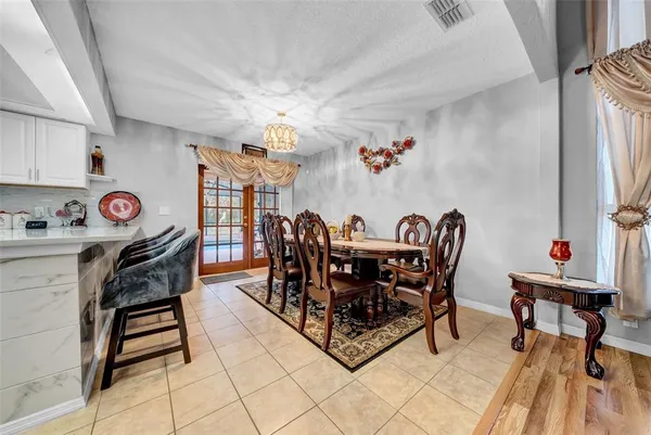 a bedroom with a large bed a chandelier and windows