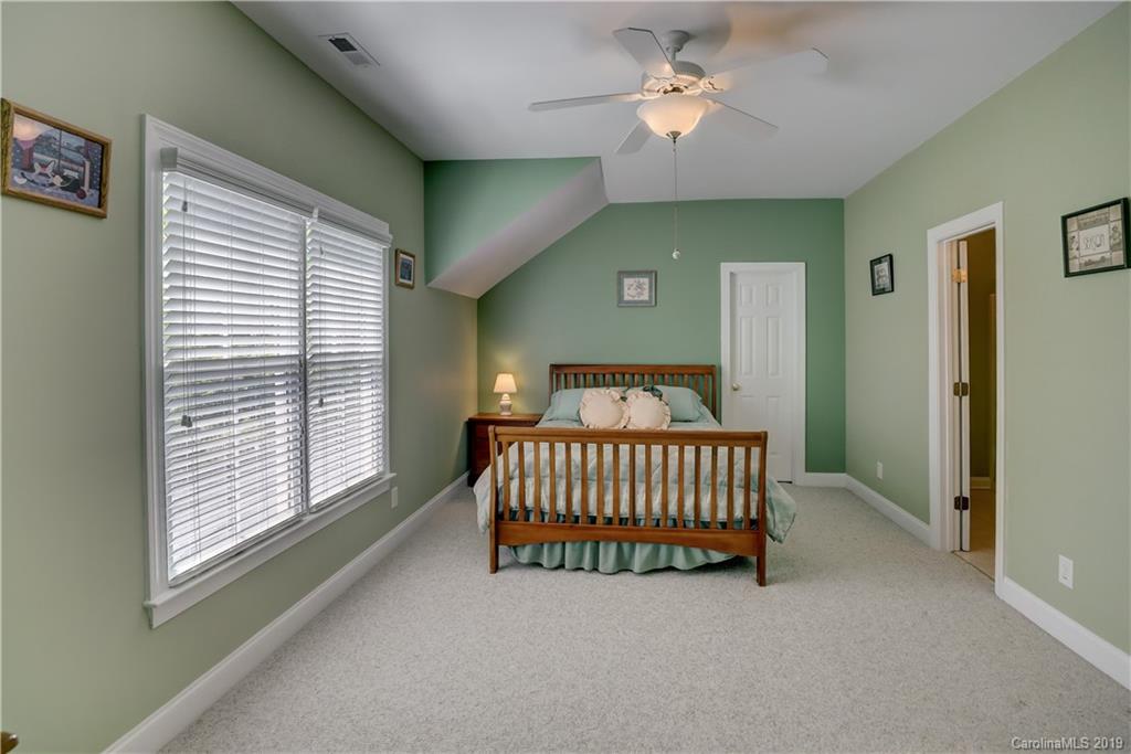 779 Julia Street Fort Mill, SC 29708 - Photo 37 of 48 a bedroom with a bed and a chandelier