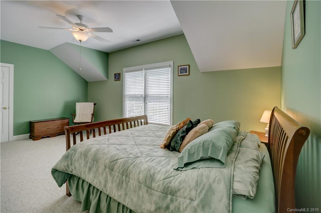 779 Julia Street Fort Mill, SC 29708 - Photo 38 of 48 a bedroom with a bed and a chandelier
