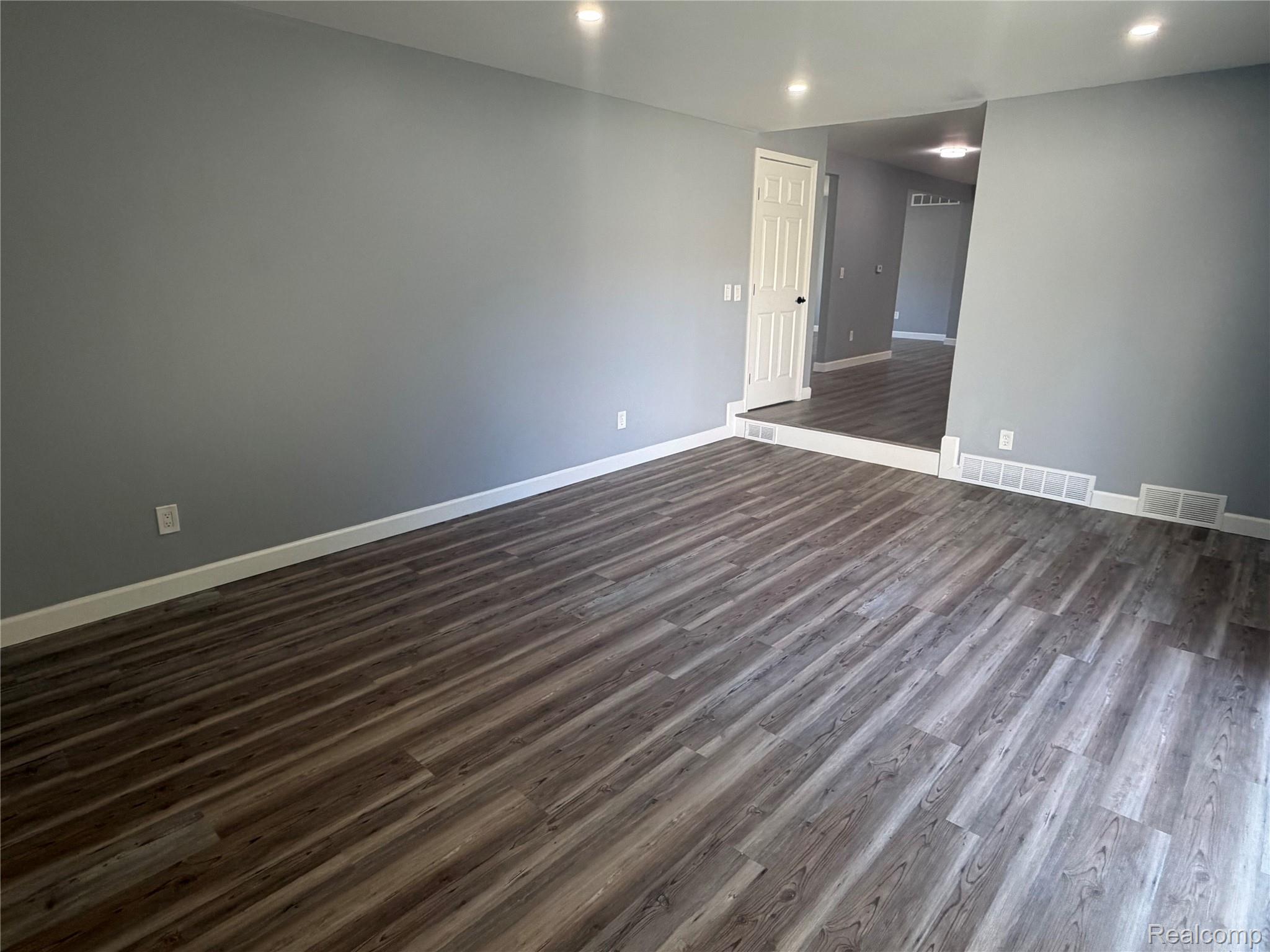 20698 Coachwood Road Riverview, MI 48193 - Photo 13 of 37 Empty room with dark wood-style flooring and recessed lighting