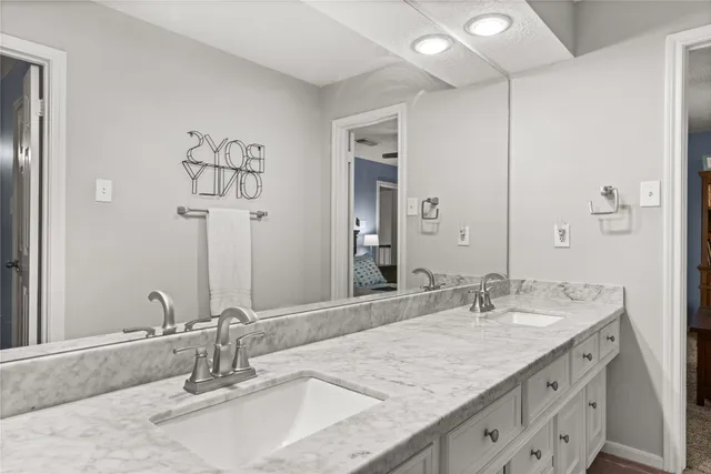 a bathroom with a granite countertop sink and a mirror