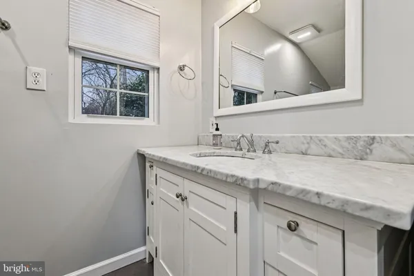 a bathroom with a granite countertop sink and a mirror
