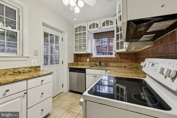 a kitchen with stainless steel appliances granite countertop a stove sink and cabinets