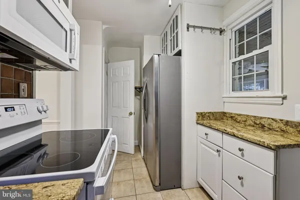 a kitchen with granite countertop a sink and a refrigerator