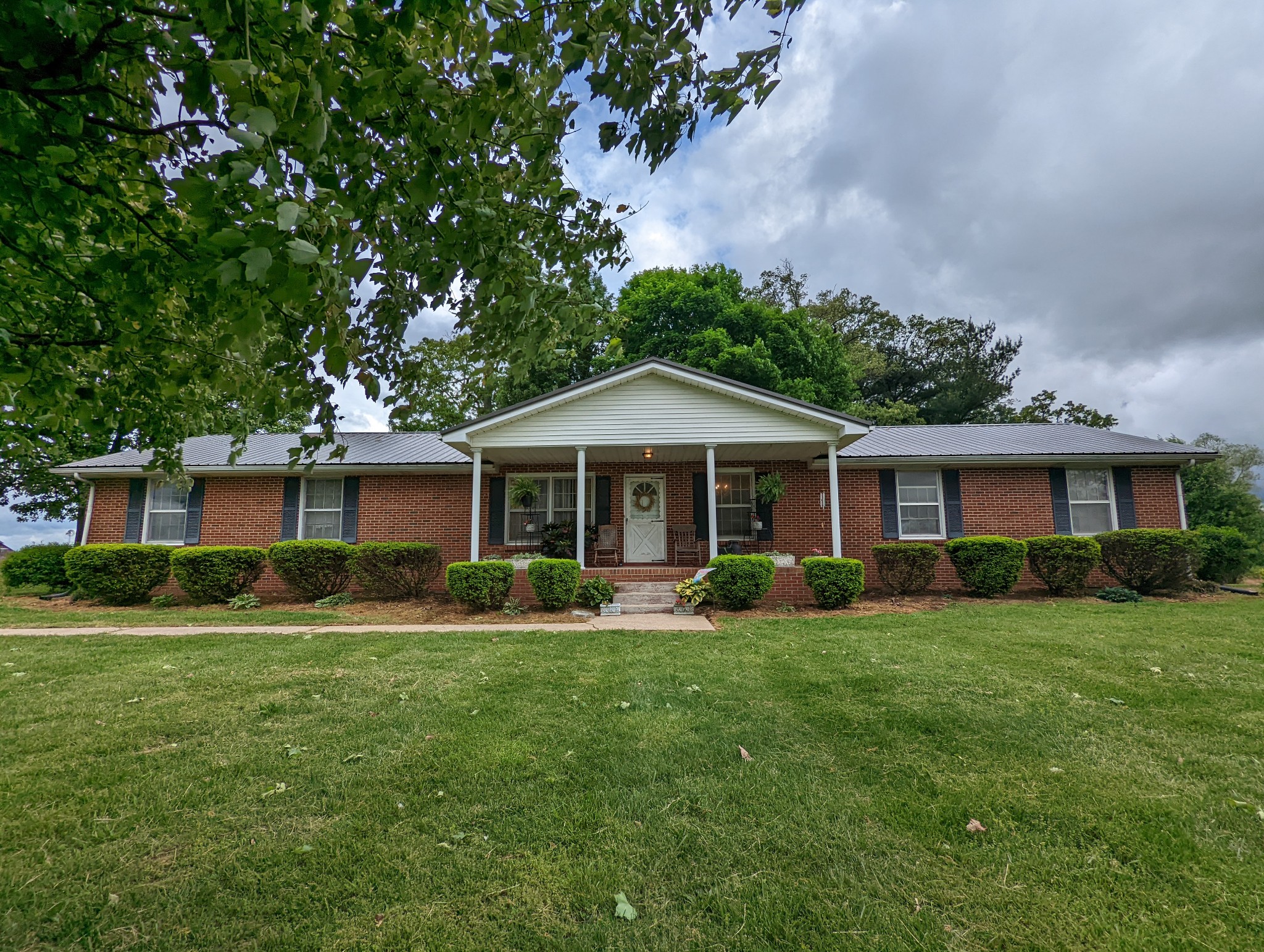 6765 Highland Road Portland, TN 37148 - Photo 1 of 31 a front view of a house with a garden