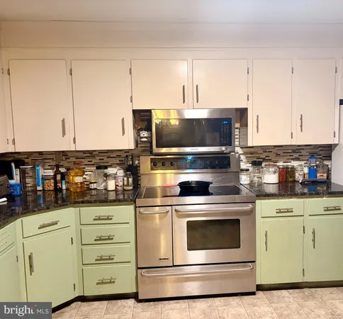 a kitchen with stainless steel appliances white cabinets and a stove a oven with white countertops