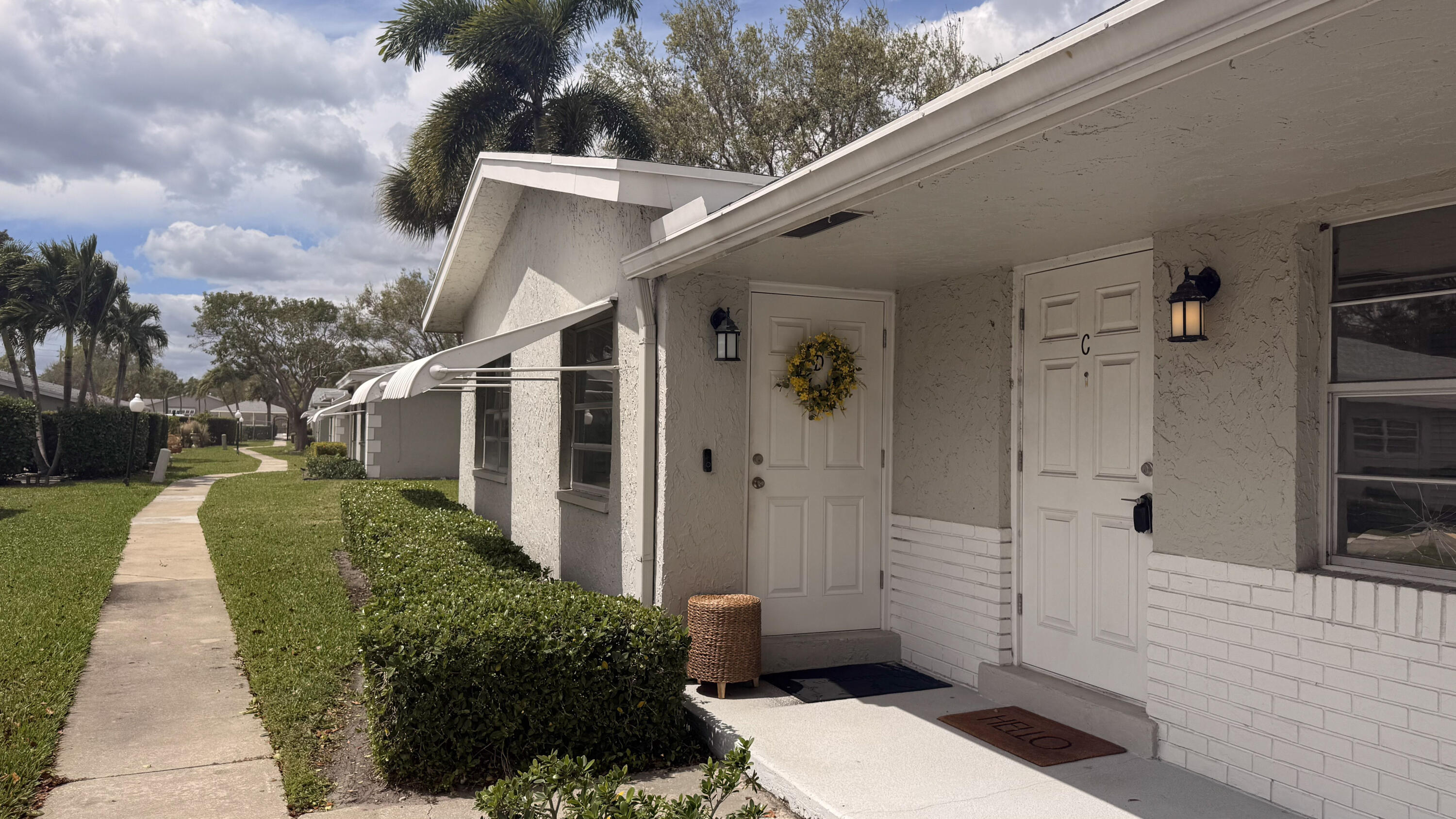 2403 Lowson Boulevard, Unit D Delray Beach, FL 33445 - Photo 3 of 21 a view of a porch with wooden floor and a yard