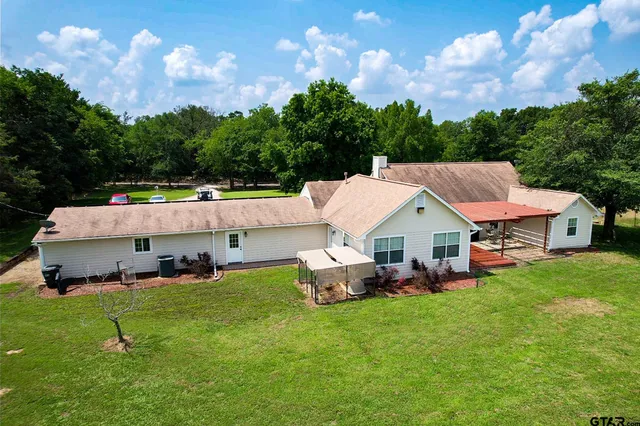 an aerial view of a house with a garden and outdoor seating