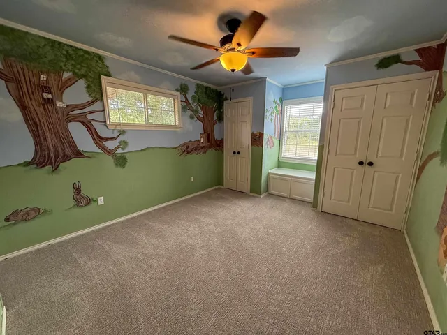 a view of a livingroom with a ceiling fan & a window