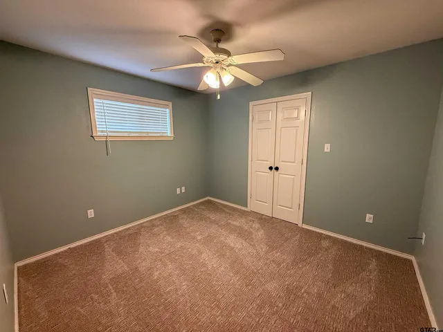 a view of an empty room with a ceiling fan