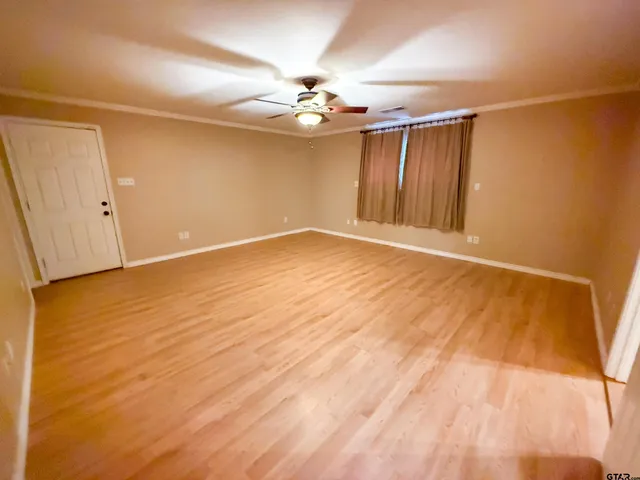 a view of an empty room with wooden floor