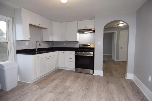 a kitchen with granite countertop a sink and a stove top oven