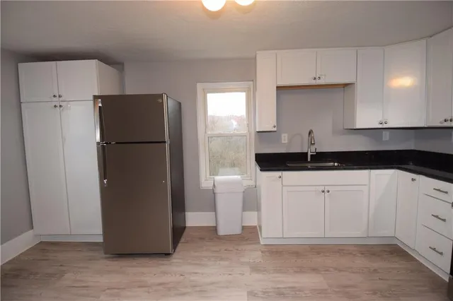 a kitchen with a refrigerator and white cabinets