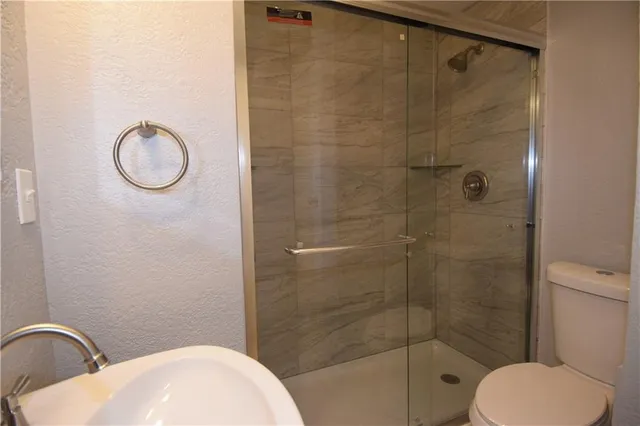 a bathroom with a toilet sink vanity and shower