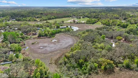 an aerial view of a houses with outdoor space and trees