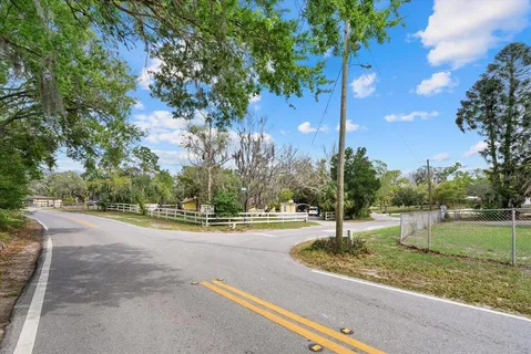 a view of a house with a yard and a street