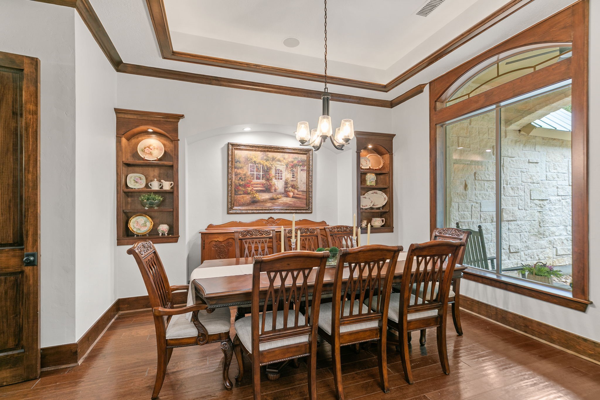 15601 Brown Road Tomball, TX 77377 - Photo 7 of 48 This dining room features elegant wood accents, a large window for natural light, built-in display shelves, and a classic chandelier, a lighted niche to display your art pieces, creating a warm and inviting atmosphere.