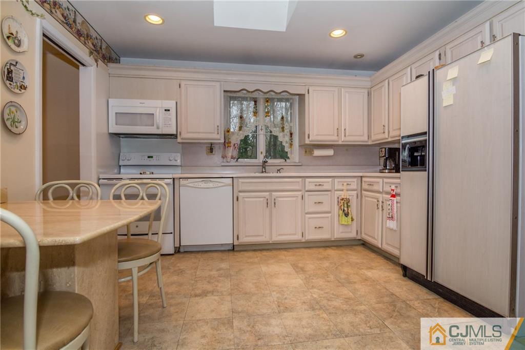 240 Hamlin Road North Brunswick, NJ 08902 - Photo 11 of 24 a kitchen with a sink a stove a refrigerator and cabinets