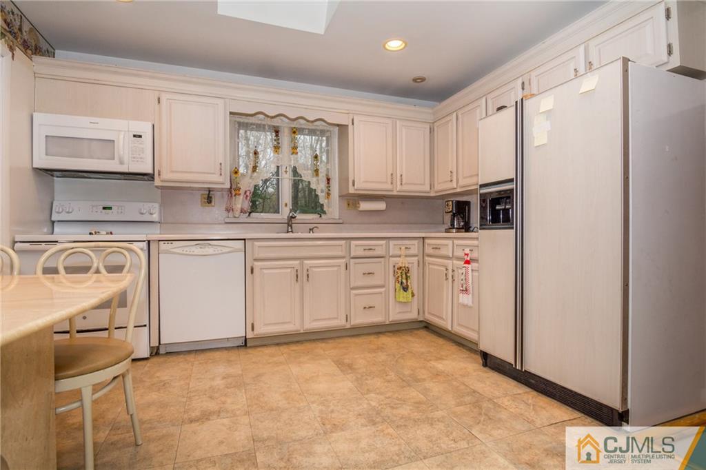 240 Hamlin Road North Brunswick, NJ 08902 - Photo 12 of 24 a kitchen with white cabinets and white appliances