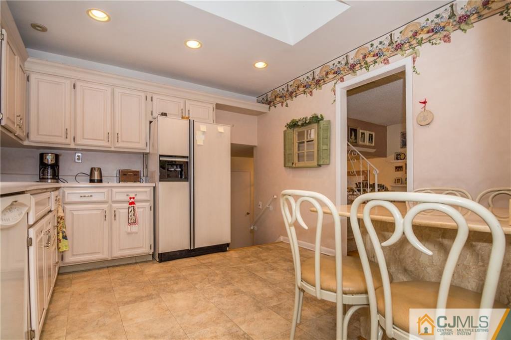 240 Hamlin Road North Brunswick, NJ 08902 - Photo 13 of 24 a kitchen with stainless steel appliances a stove a refrigerator and white cabinets with wooden floors