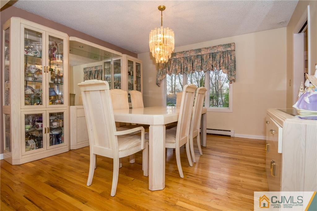240 Hamlin Road North Brunswick, NJ 08902 - Photo 9 of 24 a view of a dining room with furniture a chandelier and wooden floor
