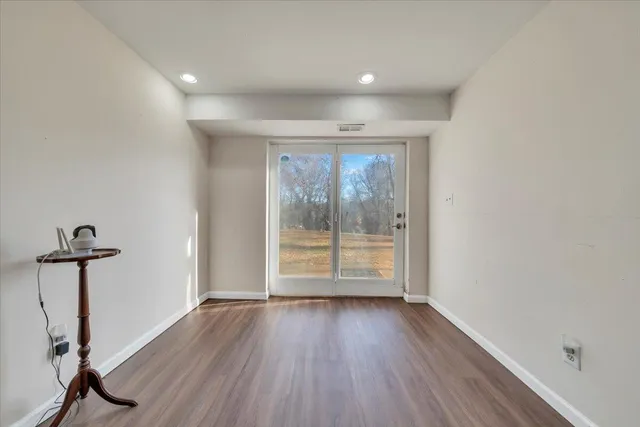 a view of empty room with wooden floor