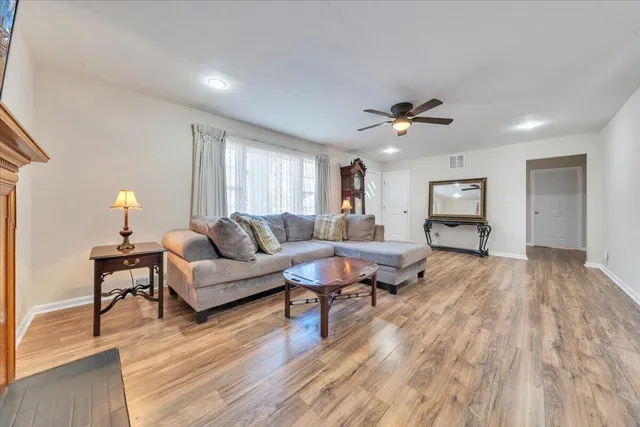 a living room with furniture and a wooden floor
