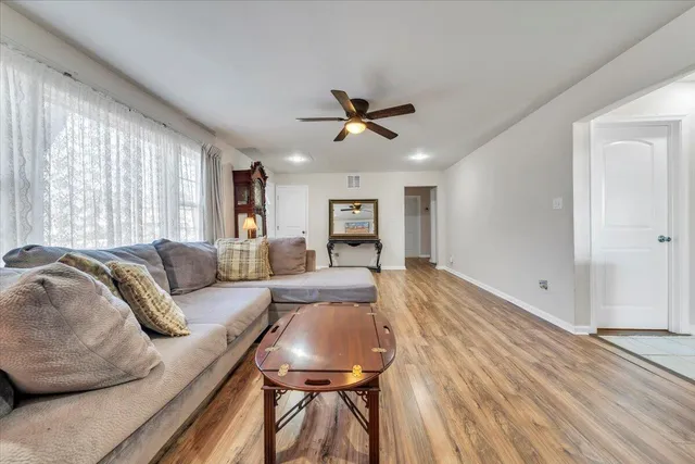 a living room with furniture and a wooden floor