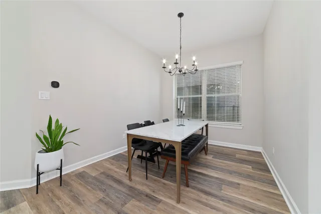 a room with chandelier fan and wooden floor