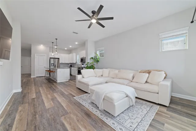 a living room with furniture and a wooden floor