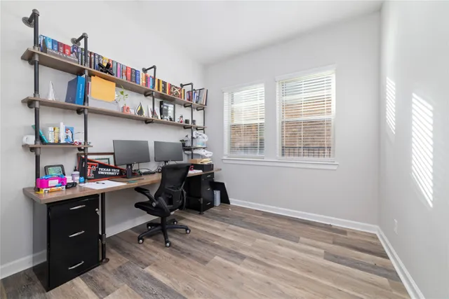 a view of a workspace with furniture and a window