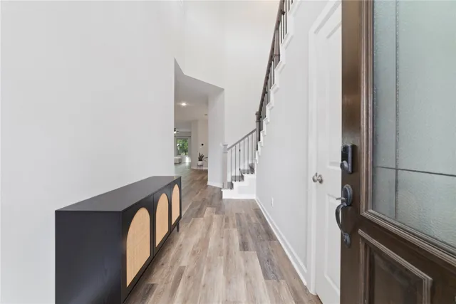 a view of a hallway with wooden floor and staircase
