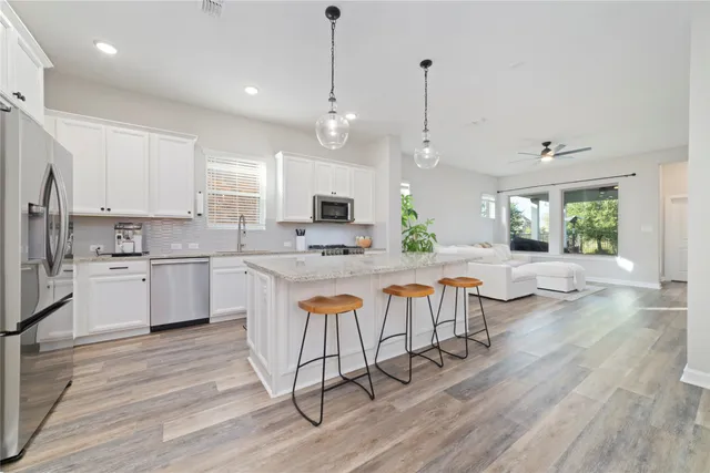 a large kitchen with lots of counter space a sink appliances and a dining table