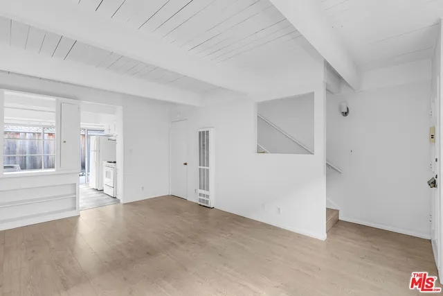 an empty room with an entryway and windows