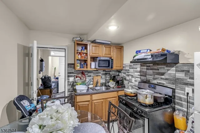 a kitchen with stainless steel appliances kitchen island granite countertop a stove and cabinets