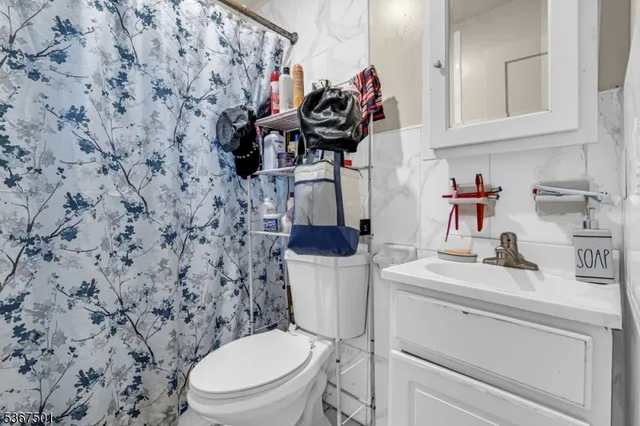 a bathroom with a sink a toilet and a shower curtain