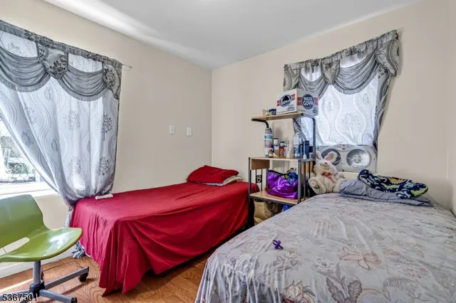 a bedroom with two beds and a chair