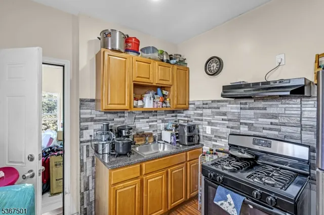 a kitchen with granite countertop a stove and cabinets