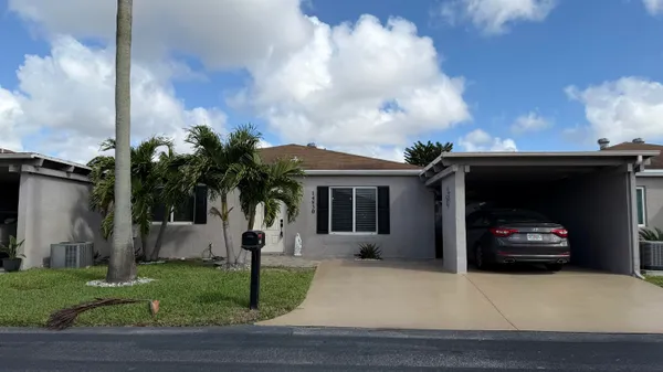 a view of a house with a yard and potted plants