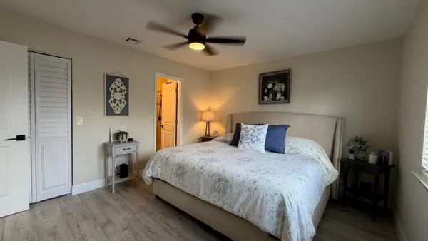 a bedroom with a bed and a ceiling fan