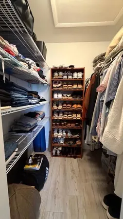 a view of walk in closet with clothes and shoes
