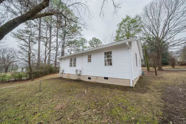 a view of a house with a backyard and trees