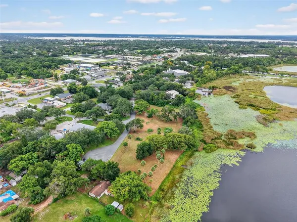 an aerial view of residential houses with outdoor space and trees