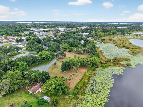 an aerial view of residential houses with outdoor space and trees