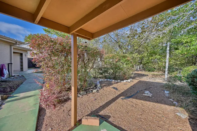 a view of a backyard with floor to ceiling window and yard