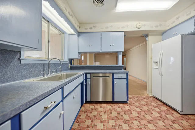 a kitchen with granite countertop a sink stove and refrigerator