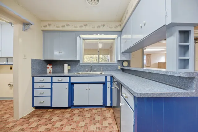 a kitchen with granite countertop a sink and a stove
