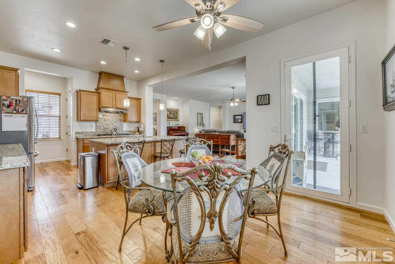 9950 Bernborough Drive Reno, NV 89521 - Photo 9 of 29 a dining room kitchen with stainless steel appliances kitchen island granite countertop a table and chairs